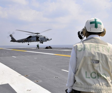 Chief Aviation Boatswain's Mate (Handling) Otis McKinney monitors logistics specialists from supply department aboard the aircraft carrier USS George Washington (CVN 73), as they secure a pole pendant to an MH-60R helicopter, assigned to the Scorpions of Helicopter Anti-Submarine Squadron Light (HSL) 49 on the flight deck during a vertical replenishment with USNS Pecos (T-AO 197).  (U.S. Navy Photo by Mass Communication Specialist 3rd Class Marcos Vazquez)
