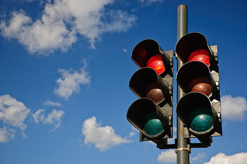 A couple of red traffic lights against a blue sky